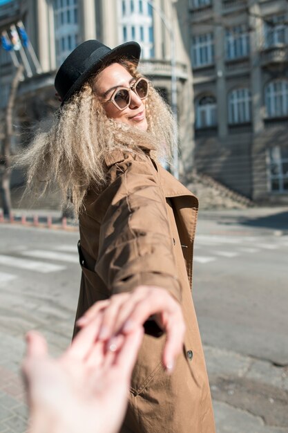 Portrait of young woman holding friends hand