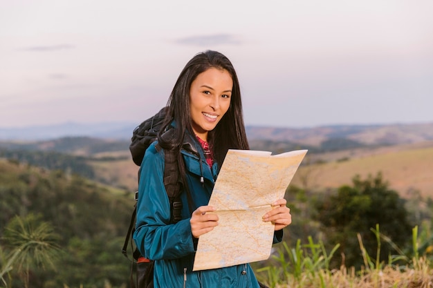 Free photo portrait of a young woman holding map