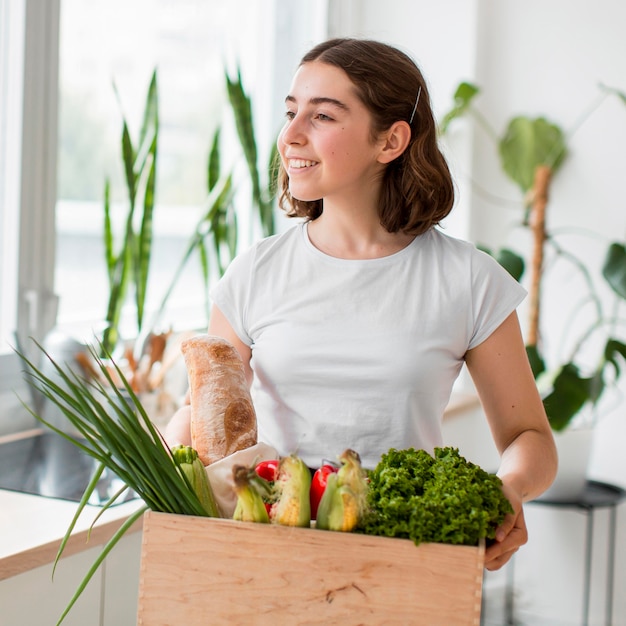 Portrait of young woman holding organic vegetables