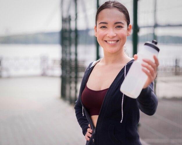 Portrait of young woman holding water bottle