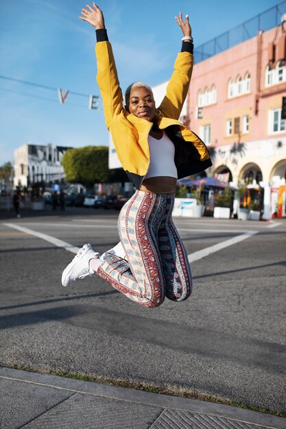 Free photo portrait of a young woman jumping outside in the city