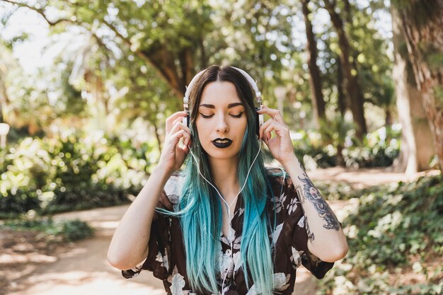 Portrait of a young woman listening music on headphone