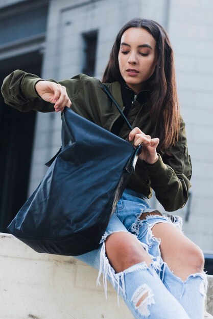 Portrait of a young woman looking in her bag
