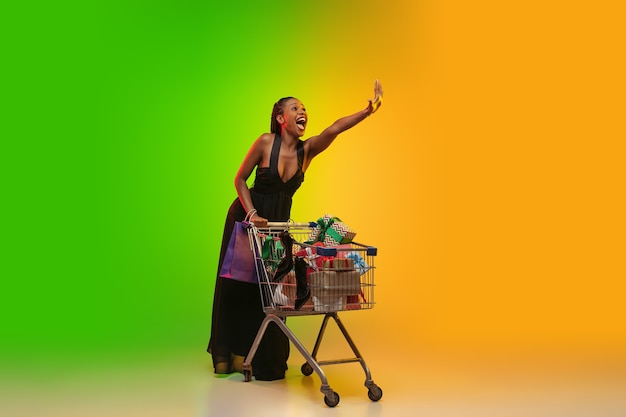 Portrait of young woman in neon light on gradient backgound.