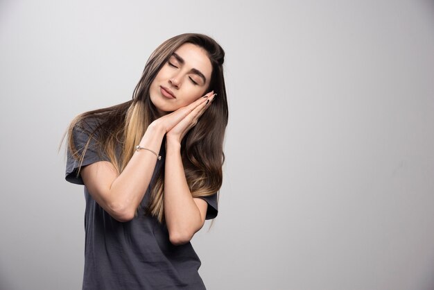 Portrait of a young woman peacefully sleeping shot on a gray background .