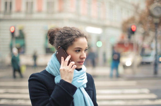 Портрет молодой женщины по телефону на улице