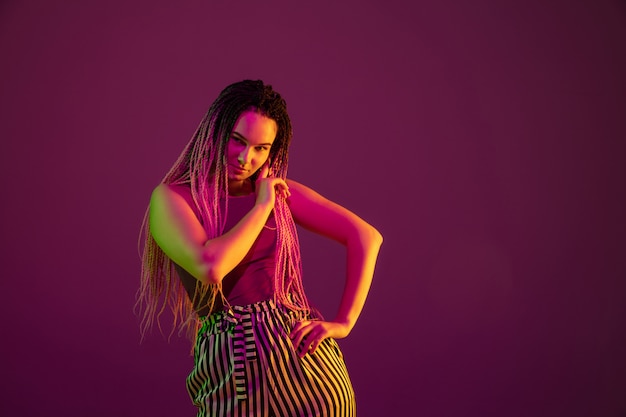 Free photo portrait of young woman on pink wall with copyspace