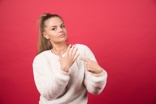 彼女の手で指している若い女性の肖像画高品質の写真