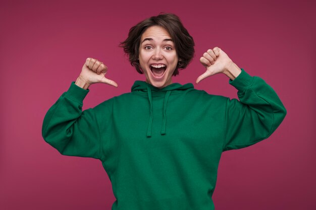 Portrait of a young woman pointing at herself