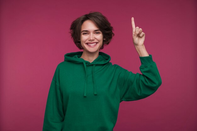 Portrait of a young woman pointing at something