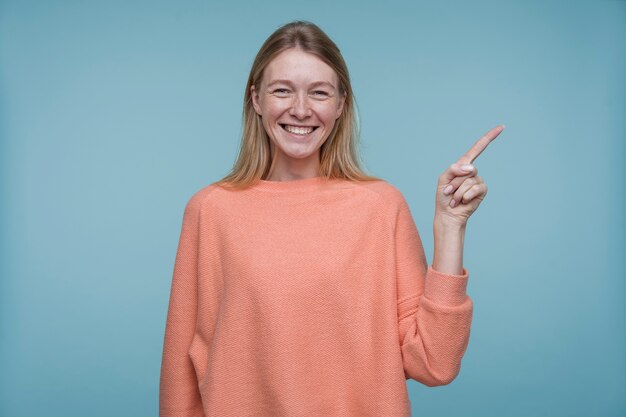 Portrait of a young woman pointing at something