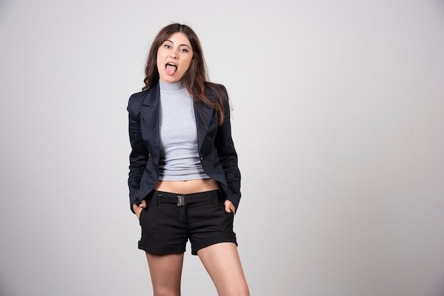 Portrait of a young woman posing and showing tongue .