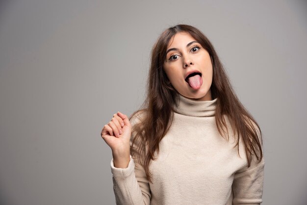 Portrait of a young woman posing and showing tongue .