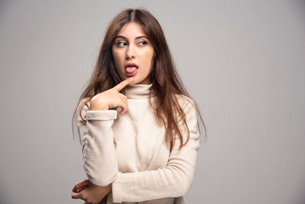 Portrait of a young woman posing and showing tongue .