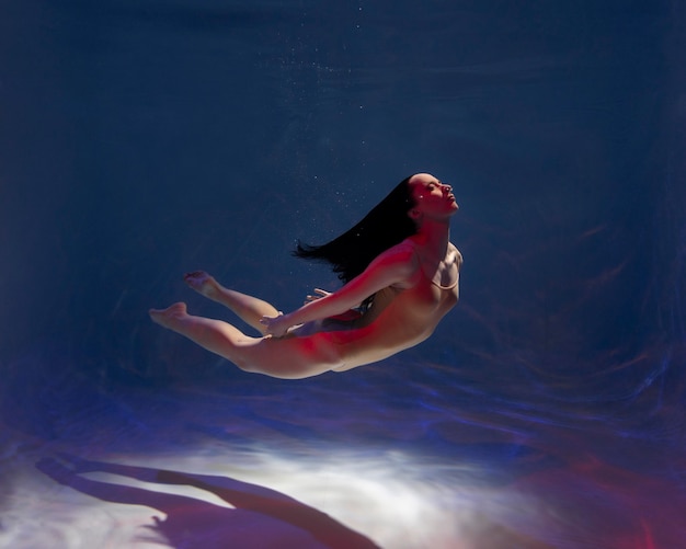 Portrait of young woman posing submerged underwater