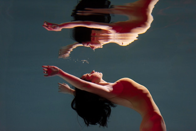 Free photo portrait of young woman posing submerged underwater