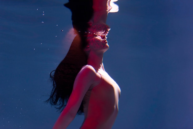 Free photo portrait of young woman posing submerged underwater