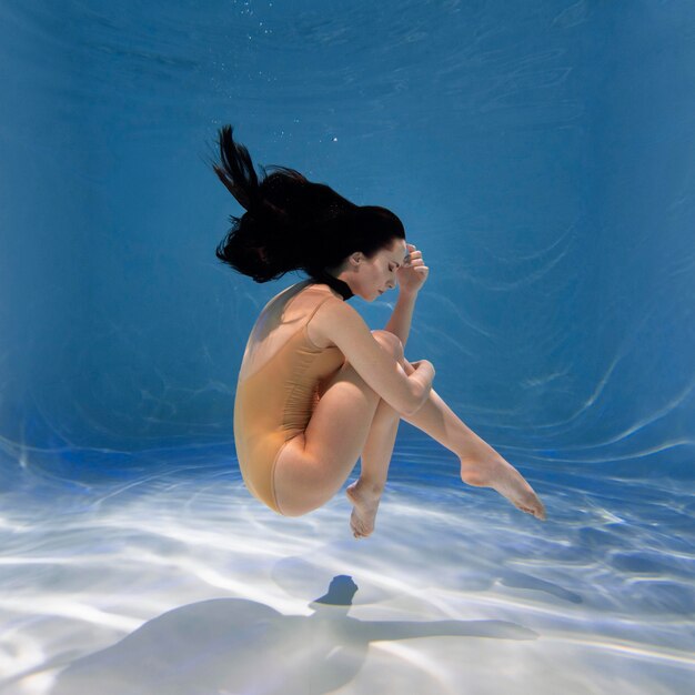 Portrait of young woman posing submerged underwater