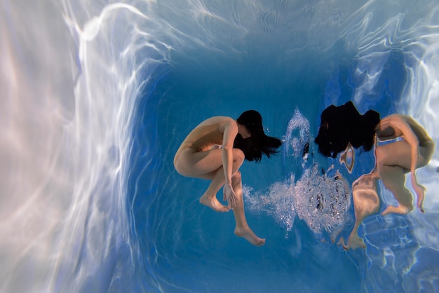 Portrait of young woman posing submerged underwater