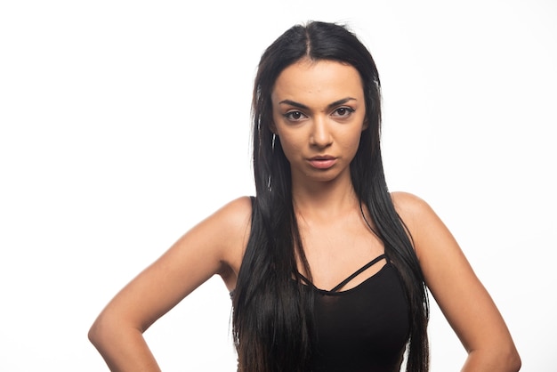 Portrait of young woman posing on white wall