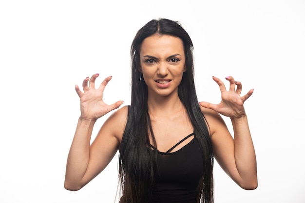 Portrait of young woman posing on white wall