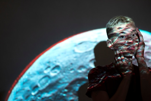 Portrait of young woman posing with universe projection texture