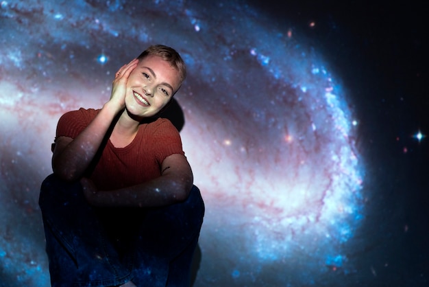 Portrait of young woman posing with universe projection texture