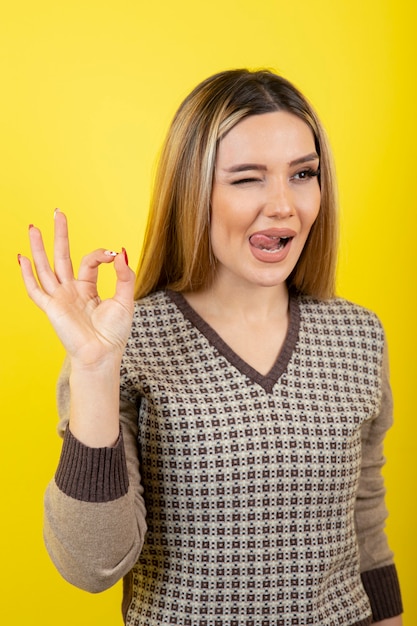 Free photo portrait of young woman posing on yellow.