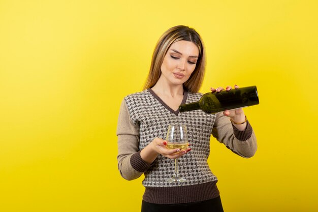 ガラスに白ワインを注ぐ若い女性の肖像画。
