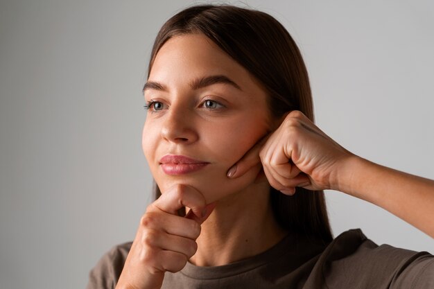 若者のために顔ヨガを練習する若い女性のポートレート