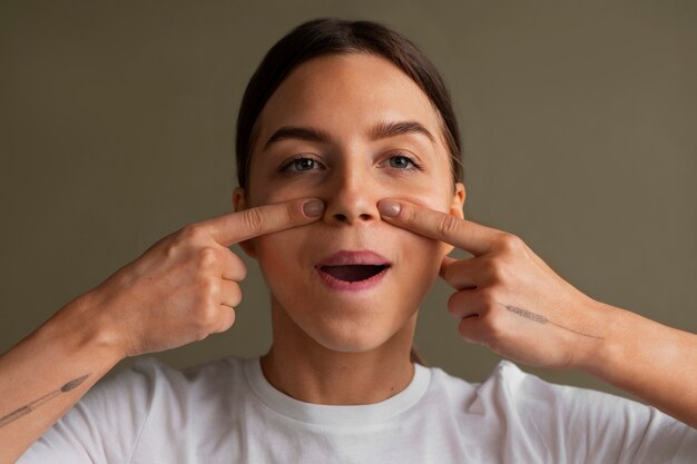 Portrait of young woman practicing facial yoga for youth