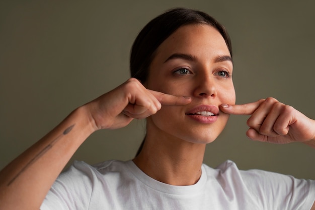 Portrait of young woman practicing facial yoga for youth