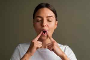 Free photo portrait of young woman practicing facial yoga for youth