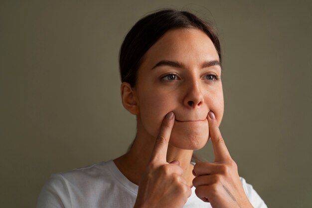 Portrait of young woman practicing facial yoga for youth