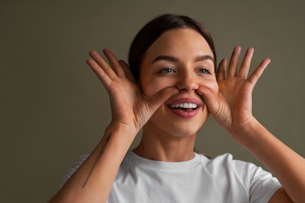 Portrait of young woman practicing facial yoga for youth
