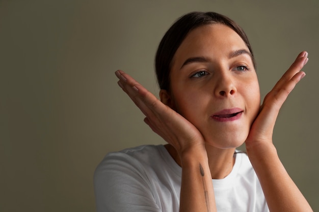 Free photo portrait of young woman practicing facial yoga for youth