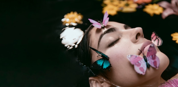 Portrait of young woman relaxing with butterflies