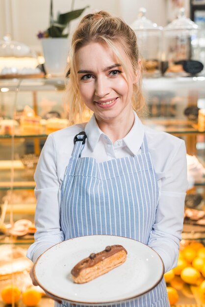 Ritratto di una giovane donna che serve la fetta di torta al cioccolato