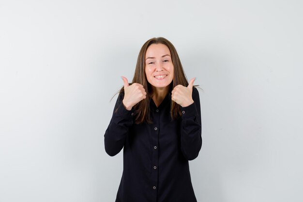 Portrait of young woman showing double thumbs up