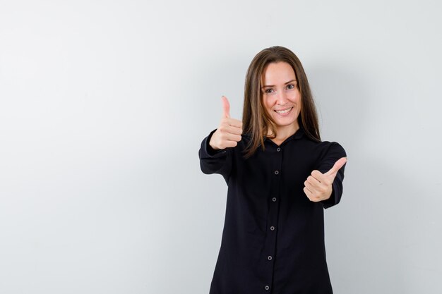 Free photo portrait of young woman showing double thumbs up