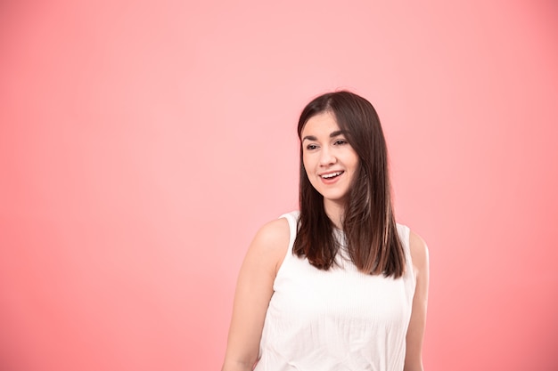 Portrait of a young woman showing emotions on isolated pink.