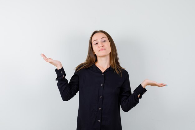 Portrait of young woman showing helpless gesture