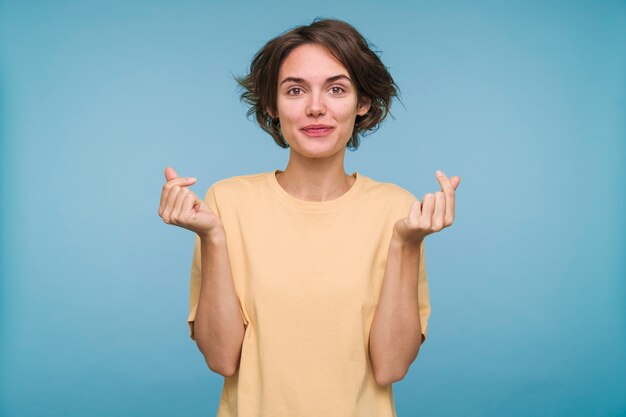 Portrait of a young woman showing money sign