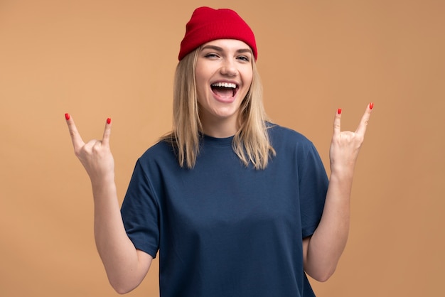 Portrait of a young woman showing the rock sign