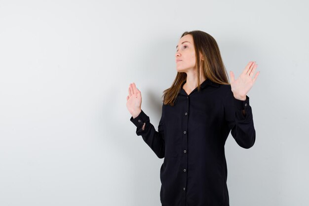 Portrait of young woman showing surrender gesture