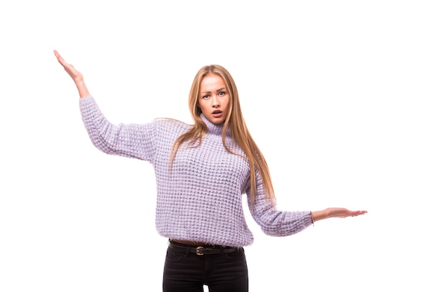 Free photo portrait of young woman shrugging her hands isolated on white wall