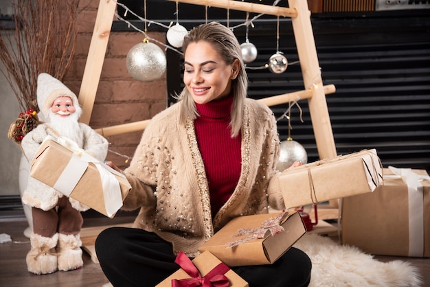 Free photo portrait of young woman sitting and posing with presents.high quality photo