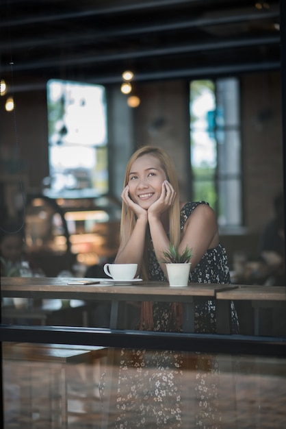 Портрет молодой женщины, улыбаясь в кафе кафе
