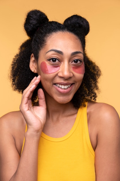 Portrait of a young woman smiling and  wearing under-eye patches