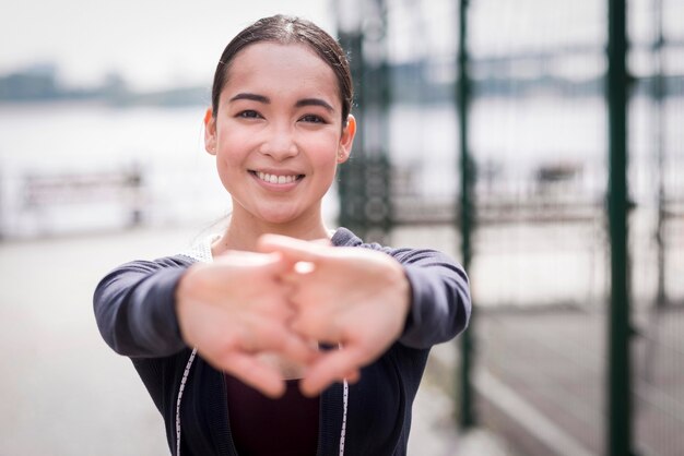 Portrait of young woman stretching outdoors